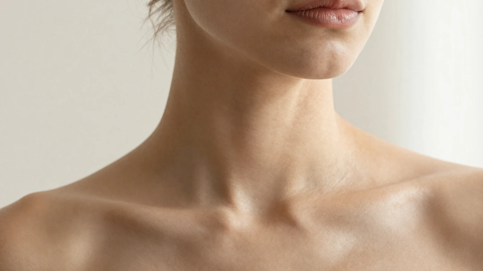 Cuello y línea de la mandíbula en luz lateral cálida, composición editorial no clínica.
